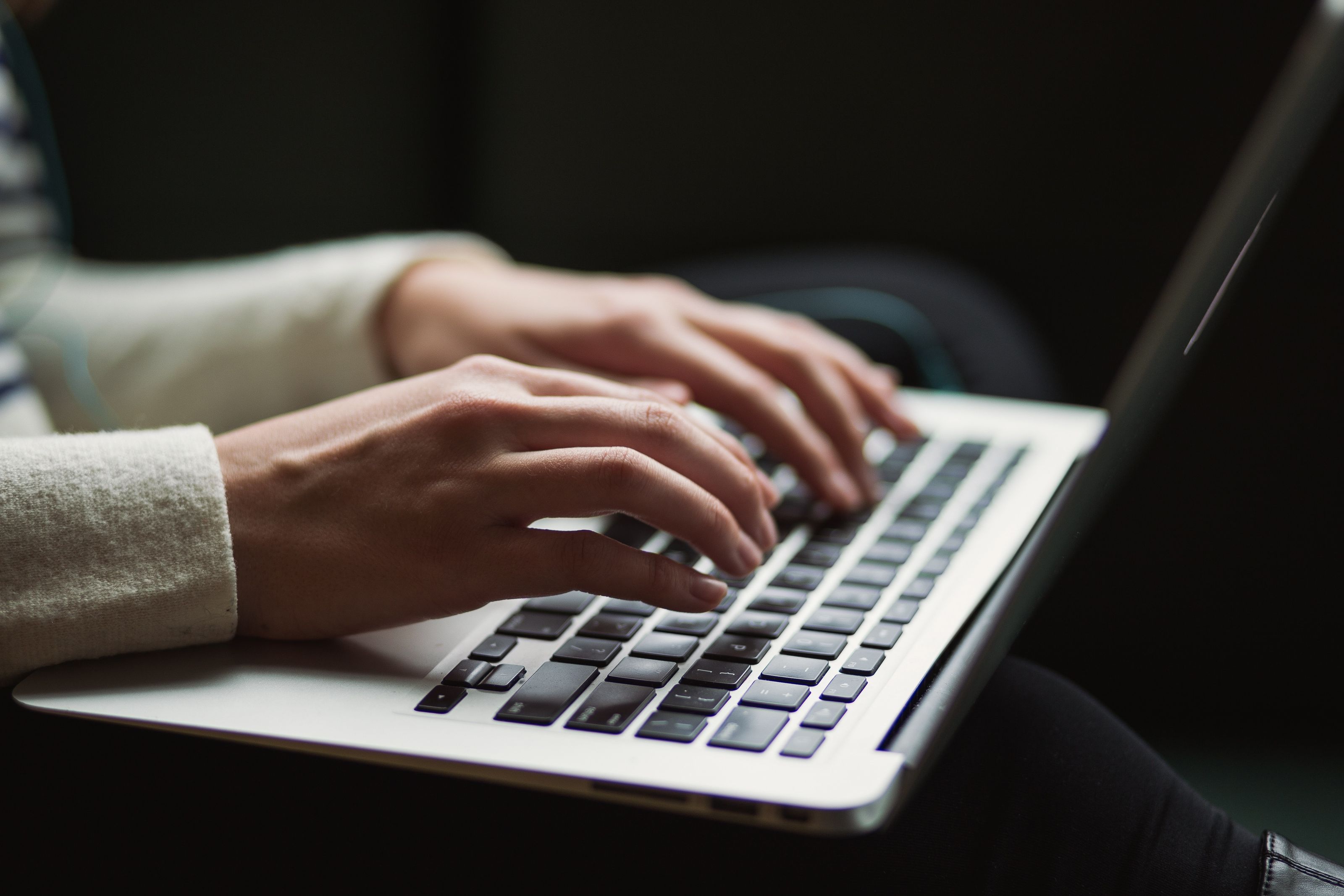A close up of a person typing on a laptop